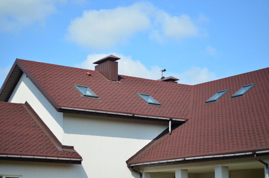 a house with a red tiled roof Caption: Water damage is the biggest example of the impact of extreme weather on roofs.
