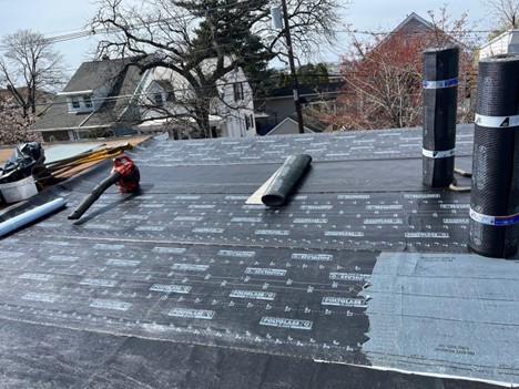 Contractors replacing a membrane on a flat roof
