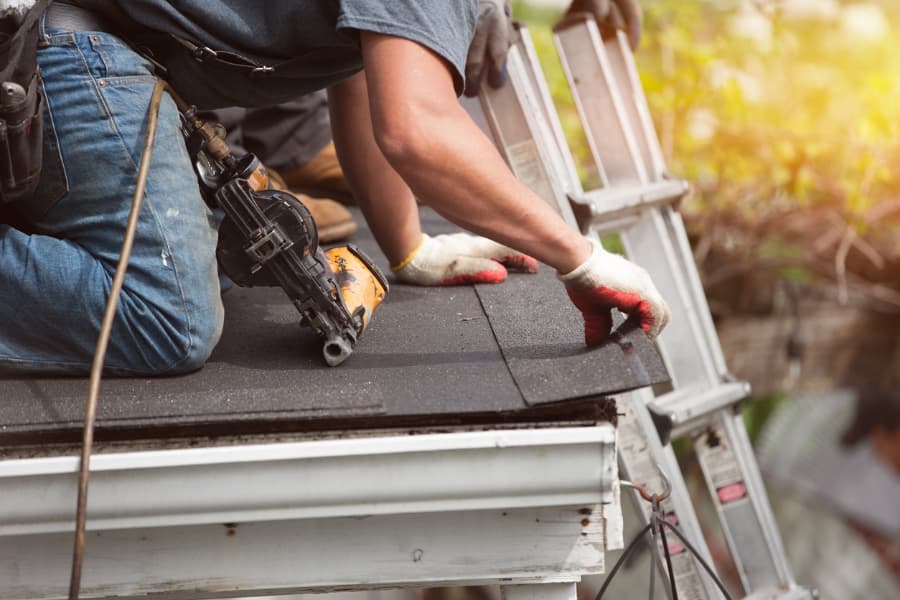 Roofers installing new shingles on home